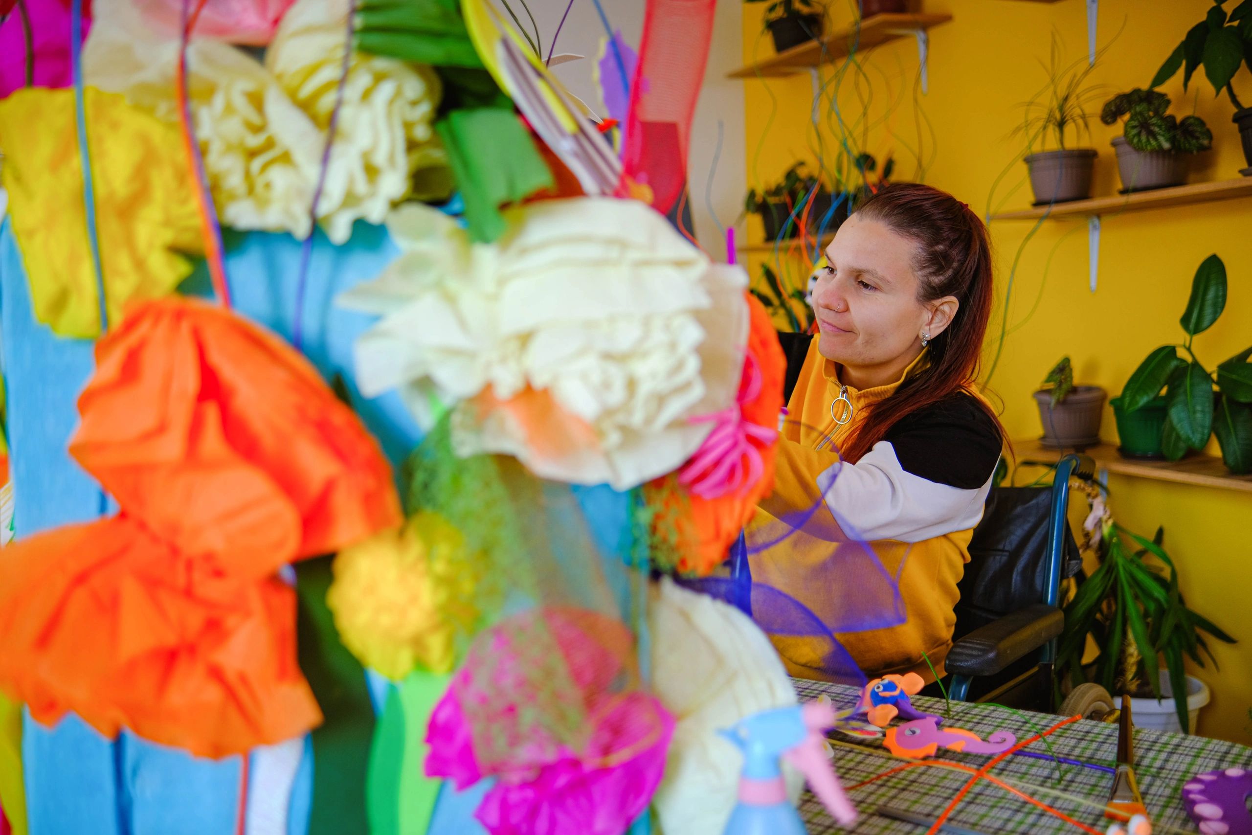 Artist making a colorful paper flower bouquet in a studio