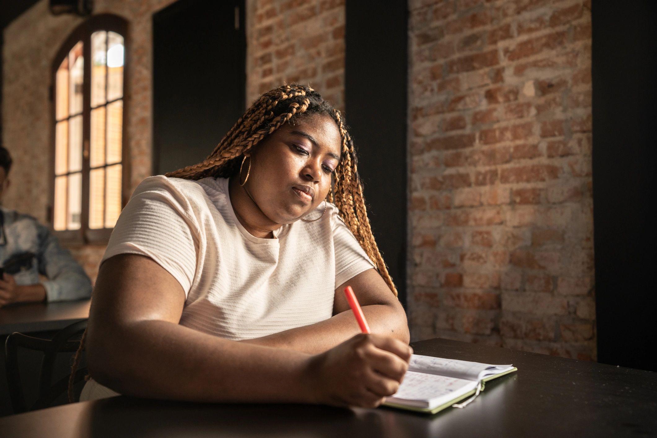 Person writing in a notebook at a desk